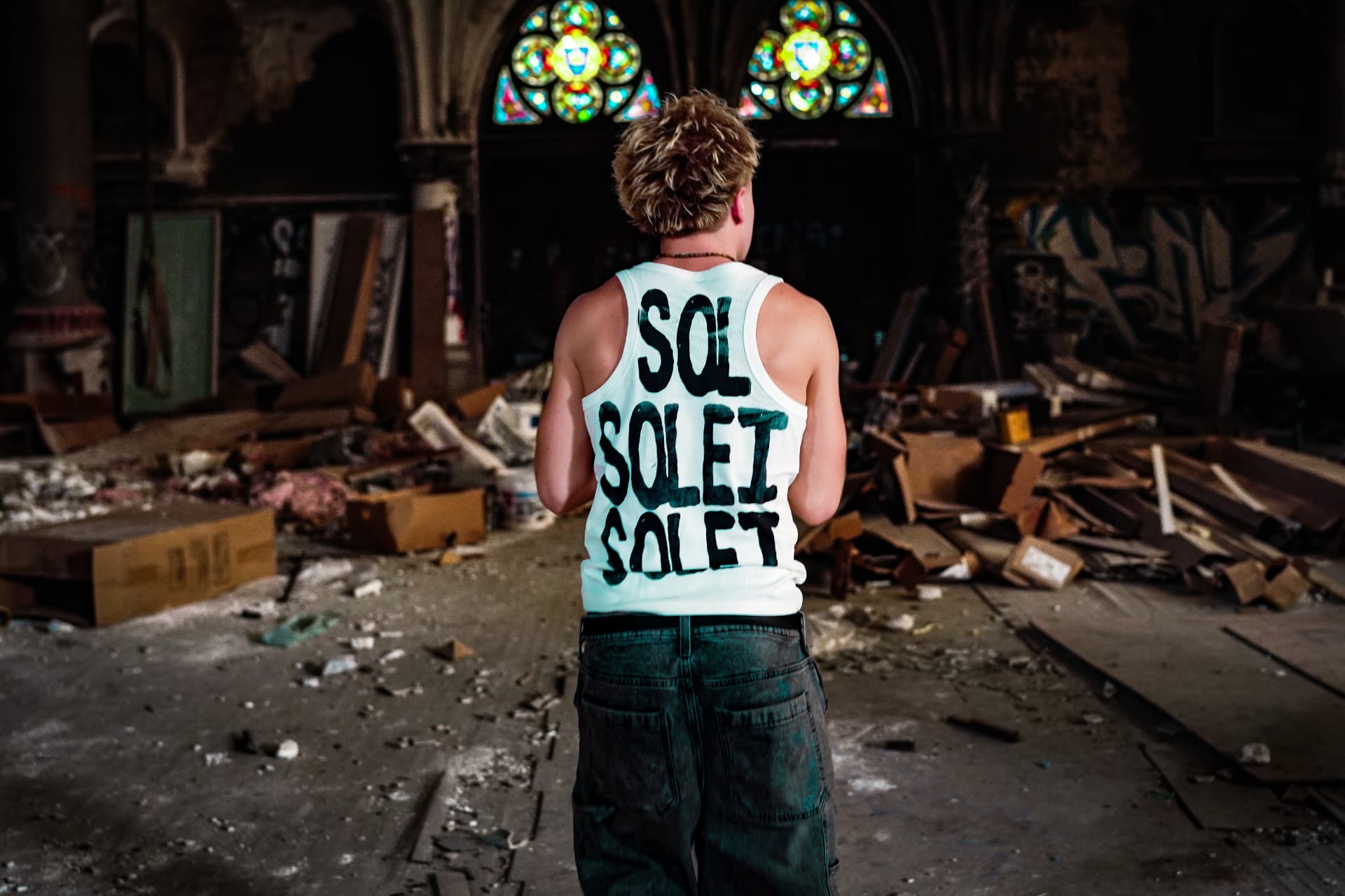 Back of a Solei tank with repeated SOLEI print inside an abandoned church