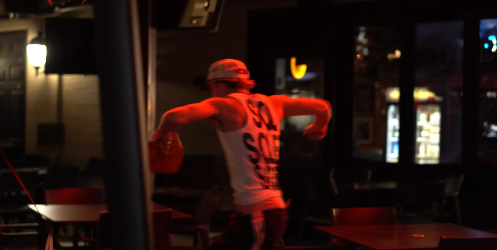 Model in a Solei tank under red light in a bar